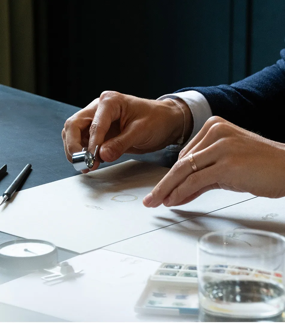 A designer working with gemstones and materials to create a jewellery piece