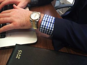 Rolex watch on wrist with suit