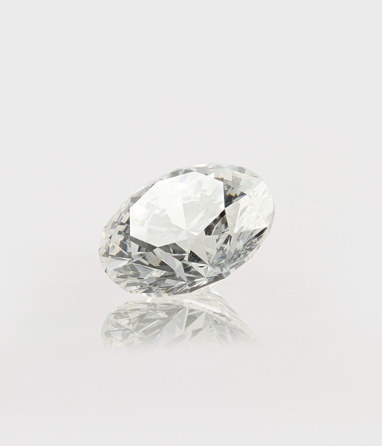 A single round brilliant cut diamond against a grey backdrop.