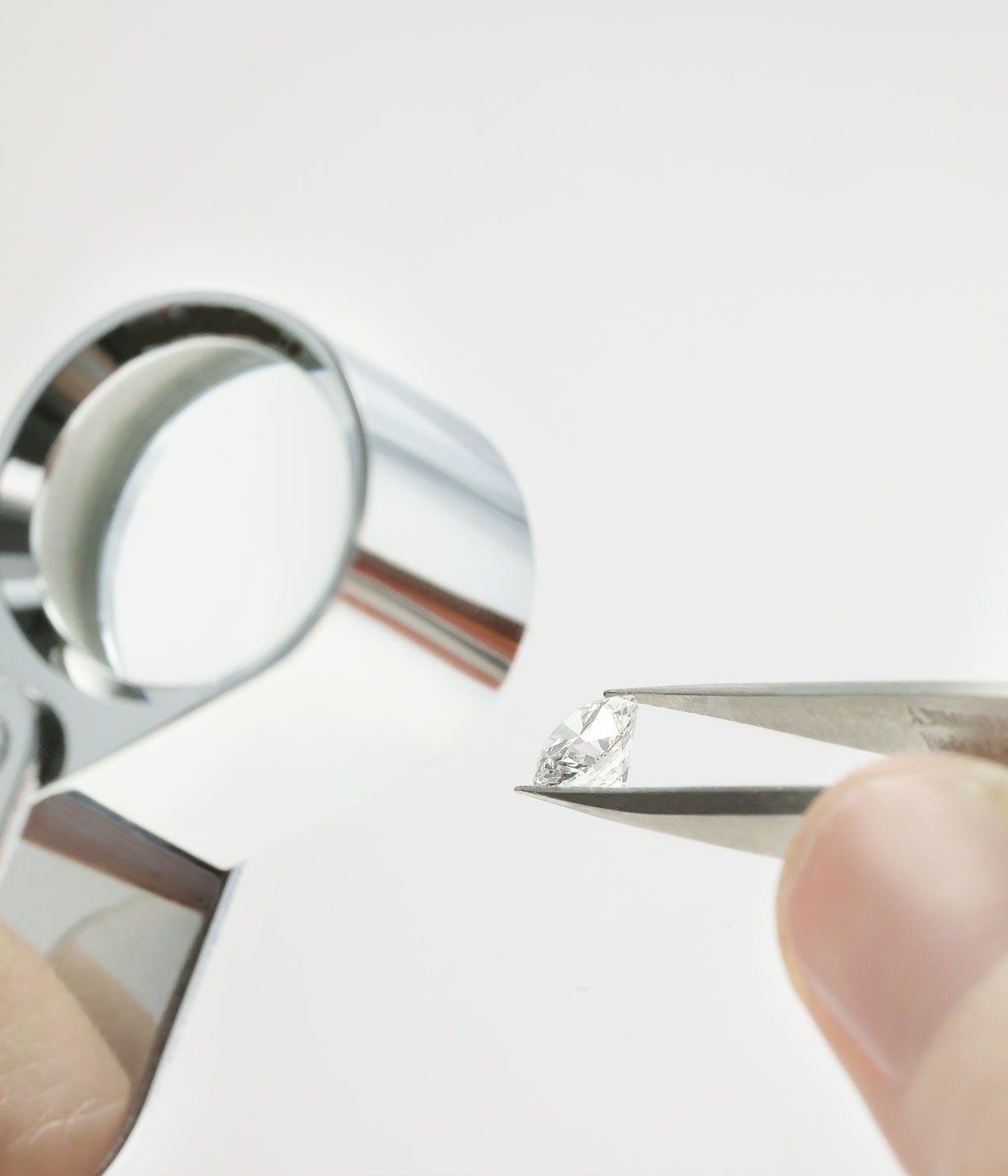 A goldsmith looking at the details of a diamond through a loupe