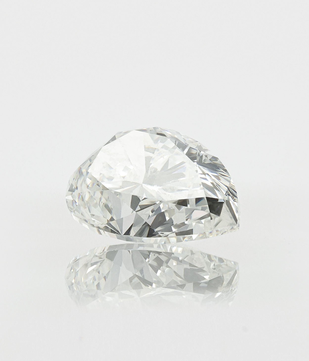 A single pear cut diamond on a grey background
