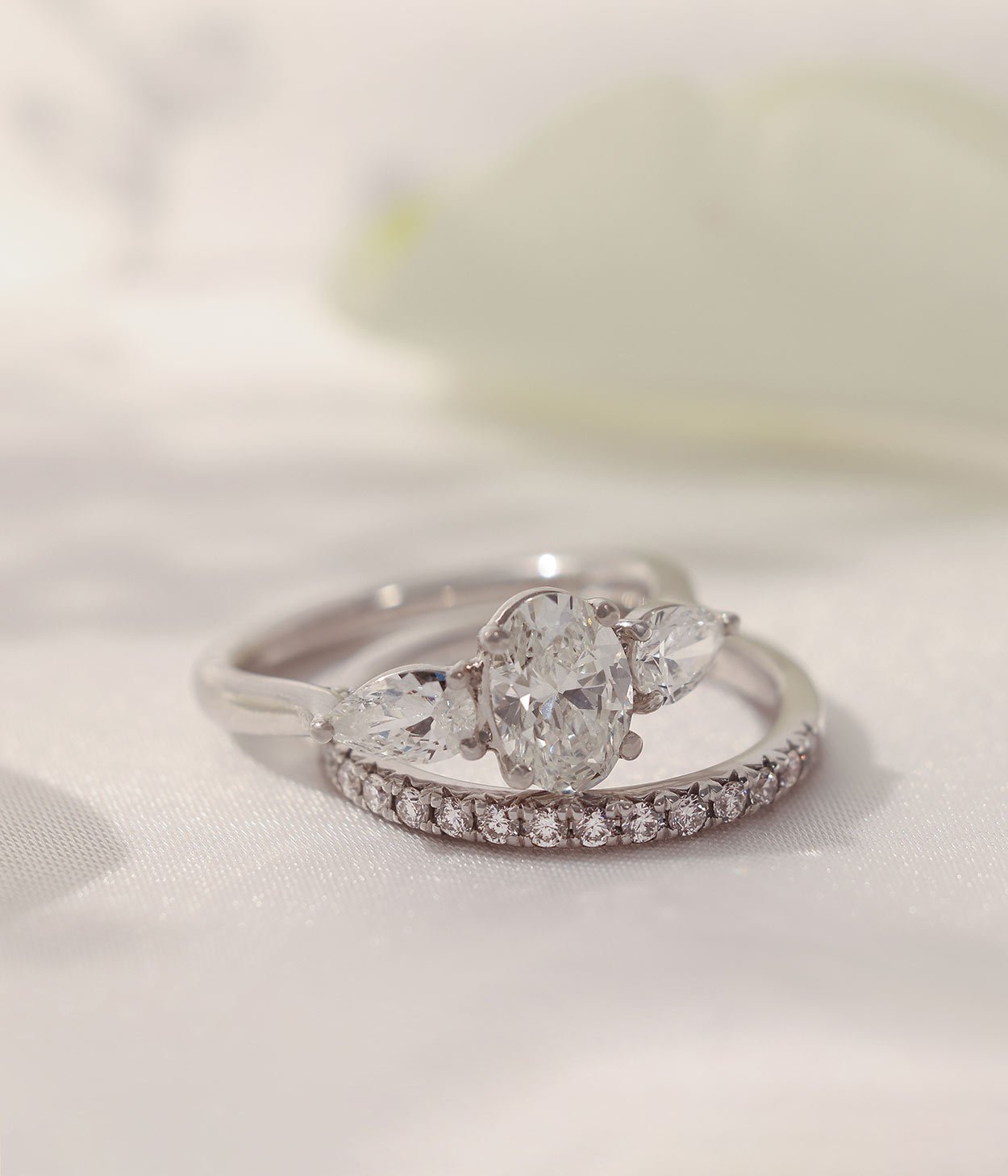 A diamond set wedding band and a three stone engagement ring, both in platinum