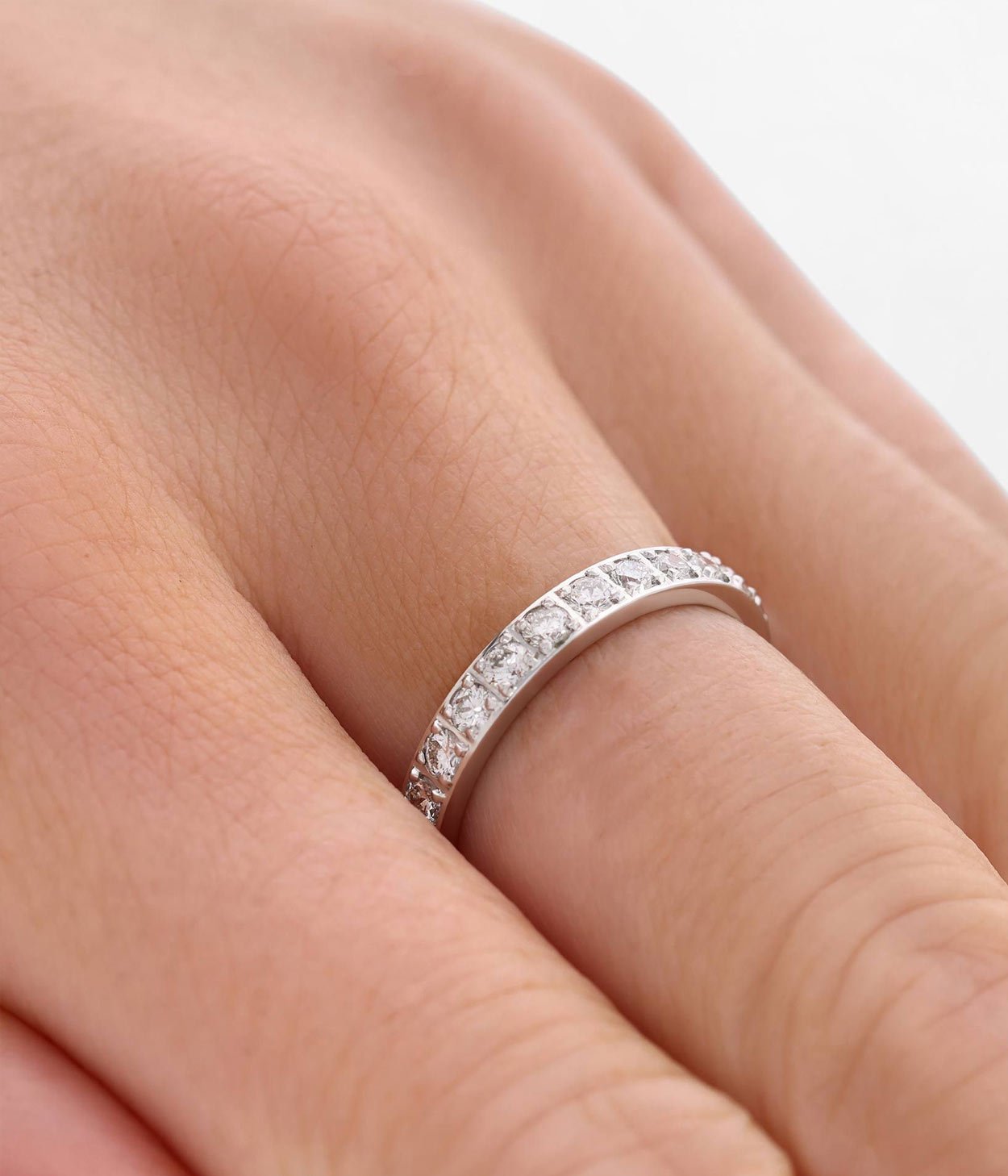 An 18ct white gold wedding band with diamonds set along the front.