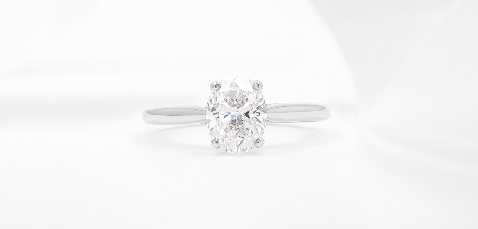 An oval cut engagement ring in platinum with four platinum claws.