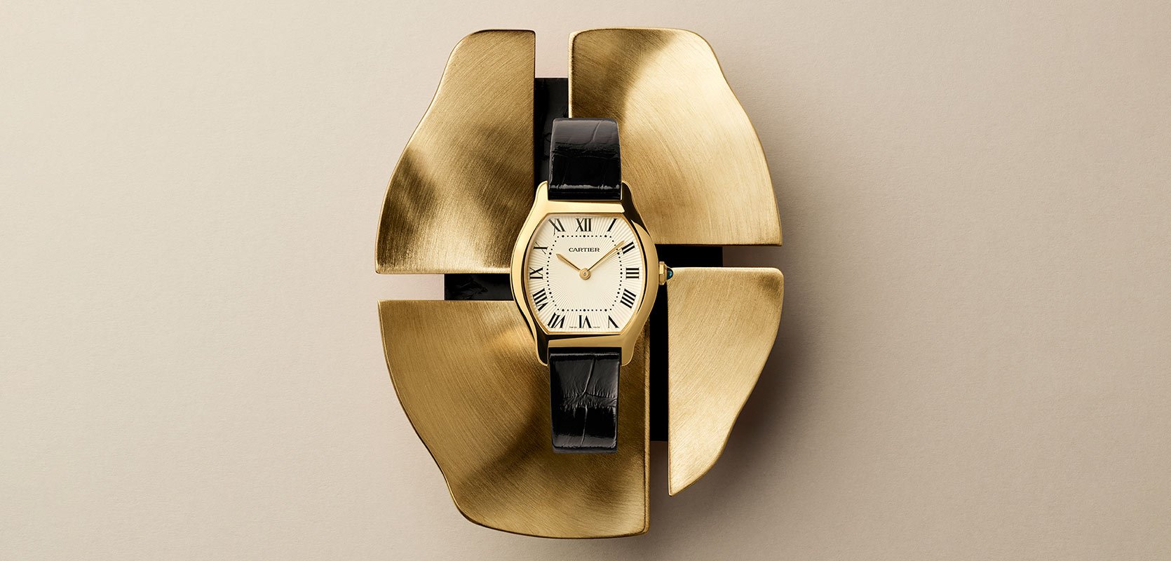A Cartier Tourne timepiece in 18ct yellow gold with a leather strap and white dial.