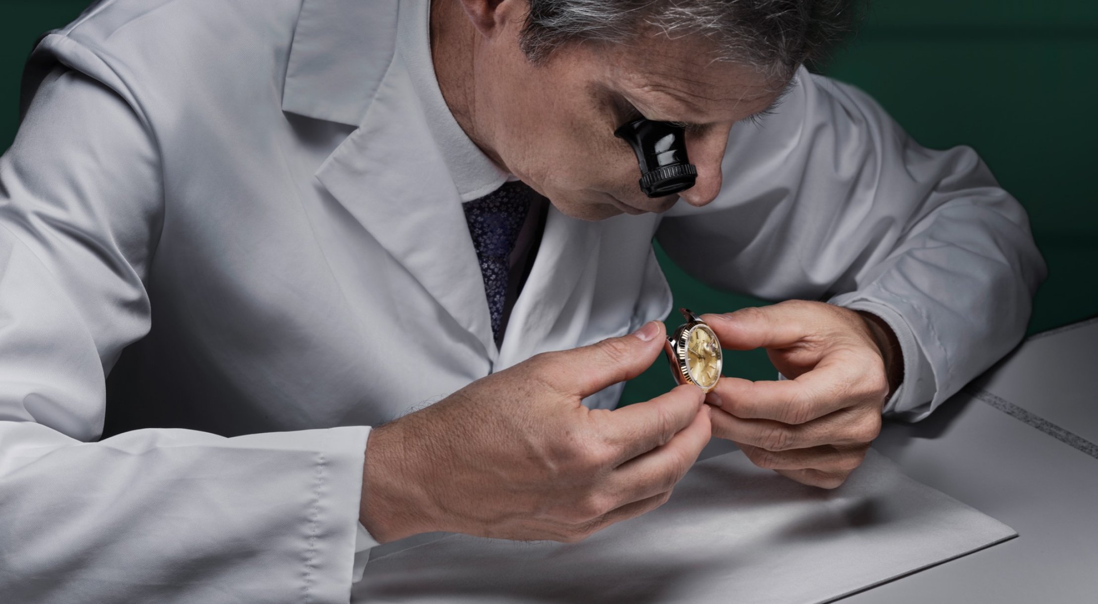A Watchmaker inspecting the case of a Rolex watch