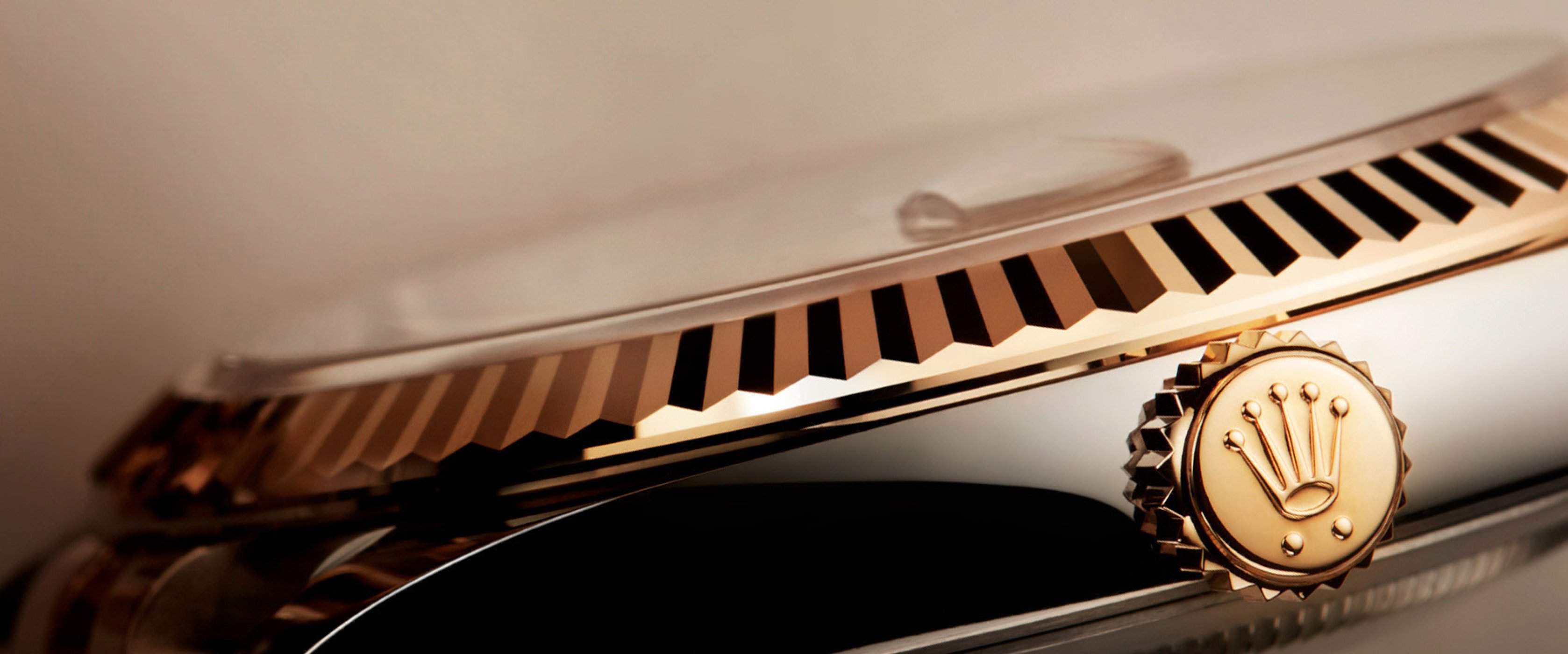 Rolex watch showing the gold fluted bezel and crown with the Rolex logo