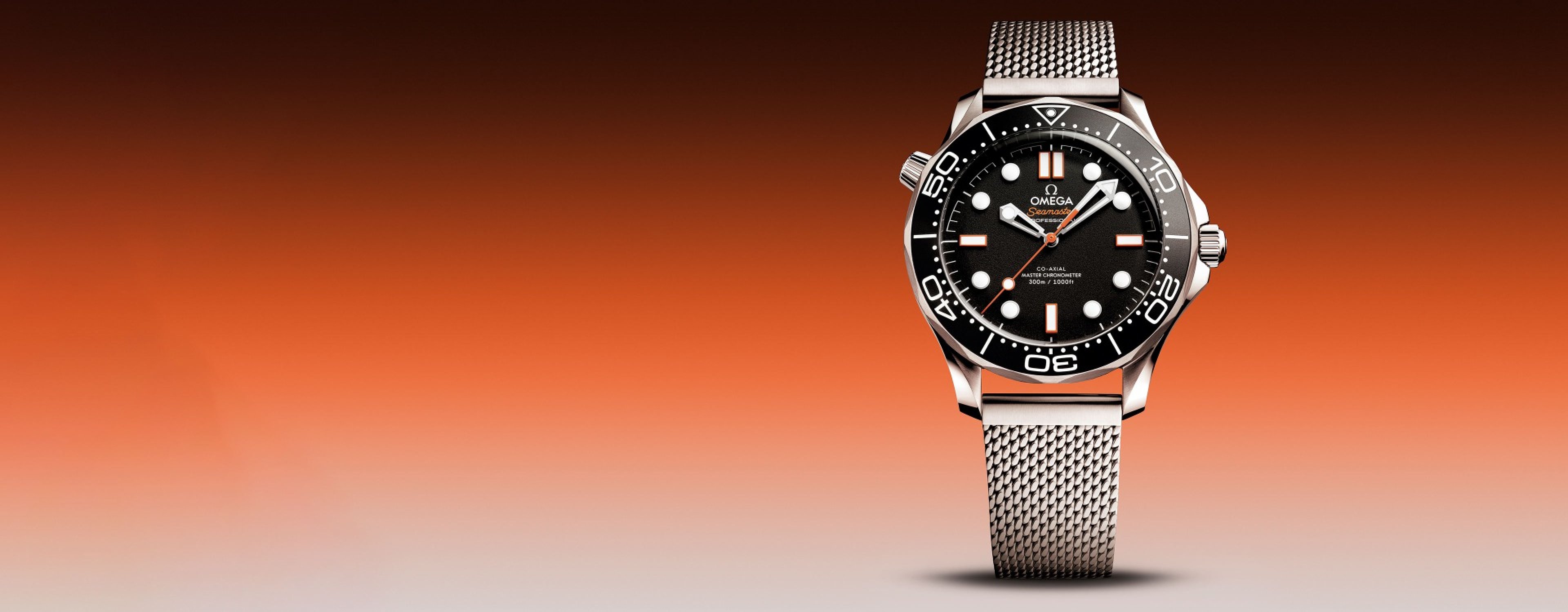 An OMEGA Seamaster watch with a black dial and bezel, orange accents and mesh steel bracelets.
