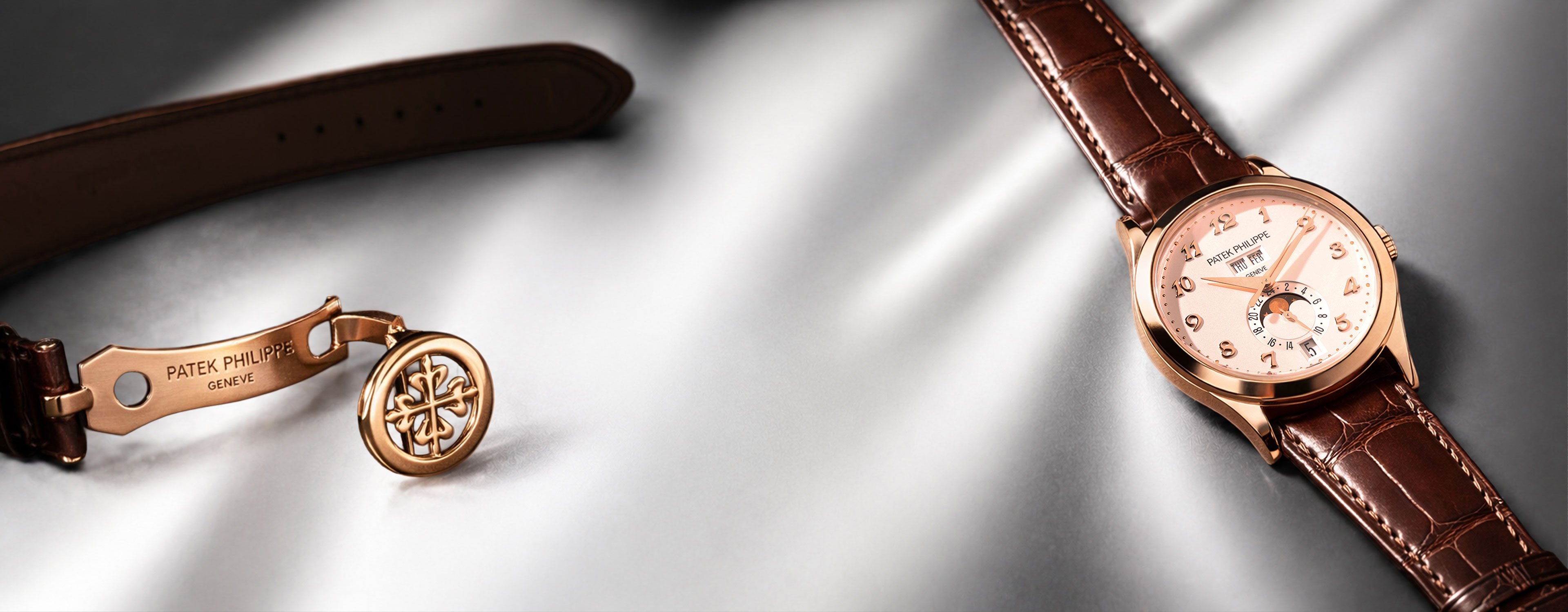 A pre-owned Patek Phillipe with a white dial,gold case and a brown leather strap