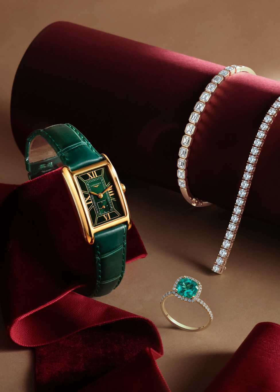 A selection of luxury christmas gifts including Longines watch with green dial and strap, an emerald rings and a diamond tennis bracelet