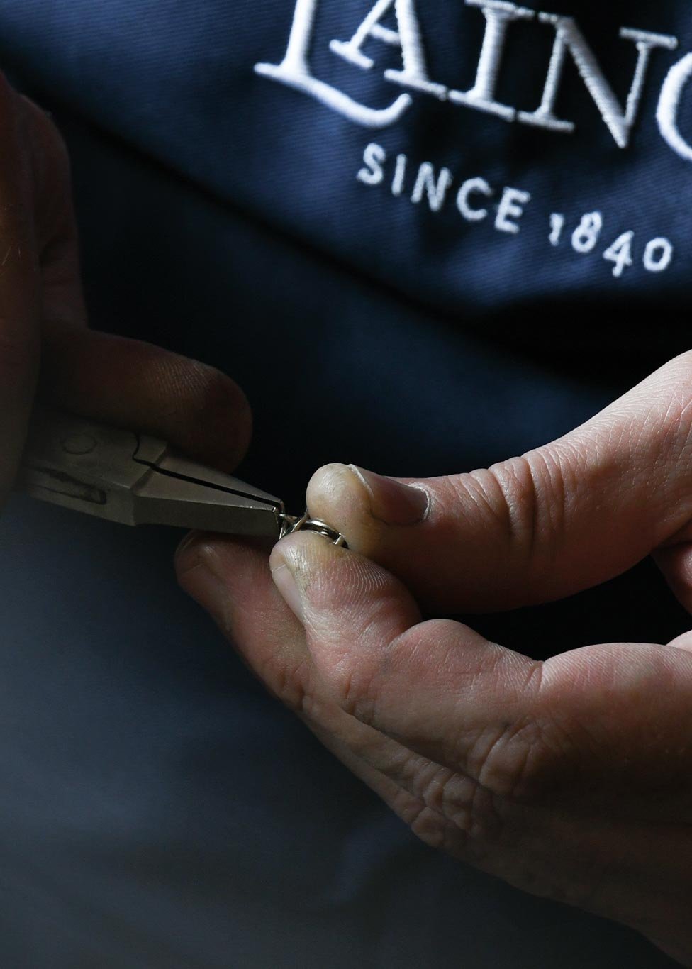 Craftsperson working on a gold charm 