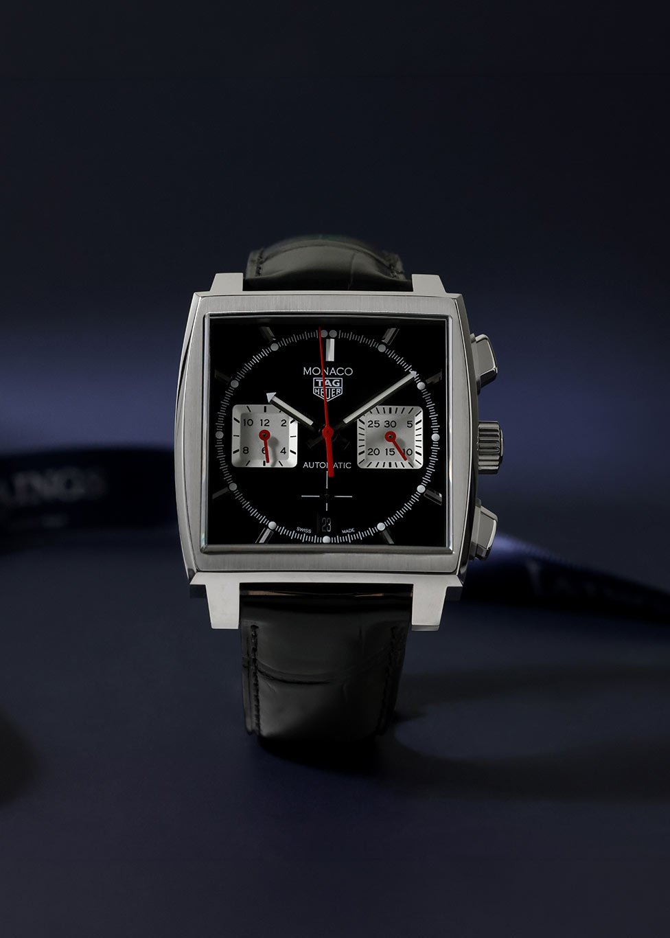 A pre-owned TAG Heuer Monaco watch in full black, with a leather strap and chronograph dial.