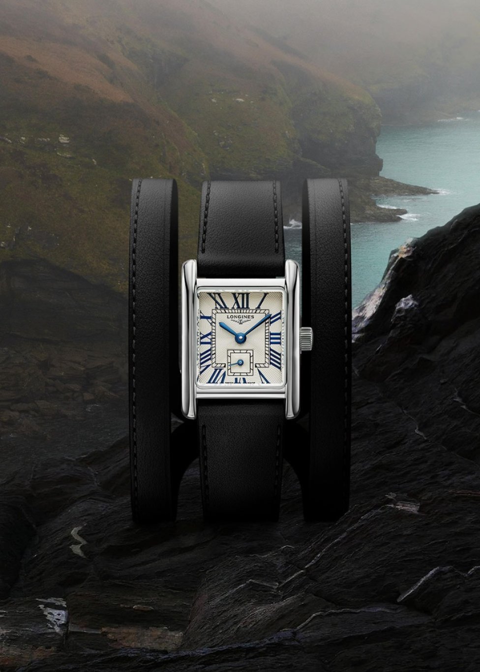 A Longines Mini Dolce Vita watch with a white dial and black wraparound leather strap.