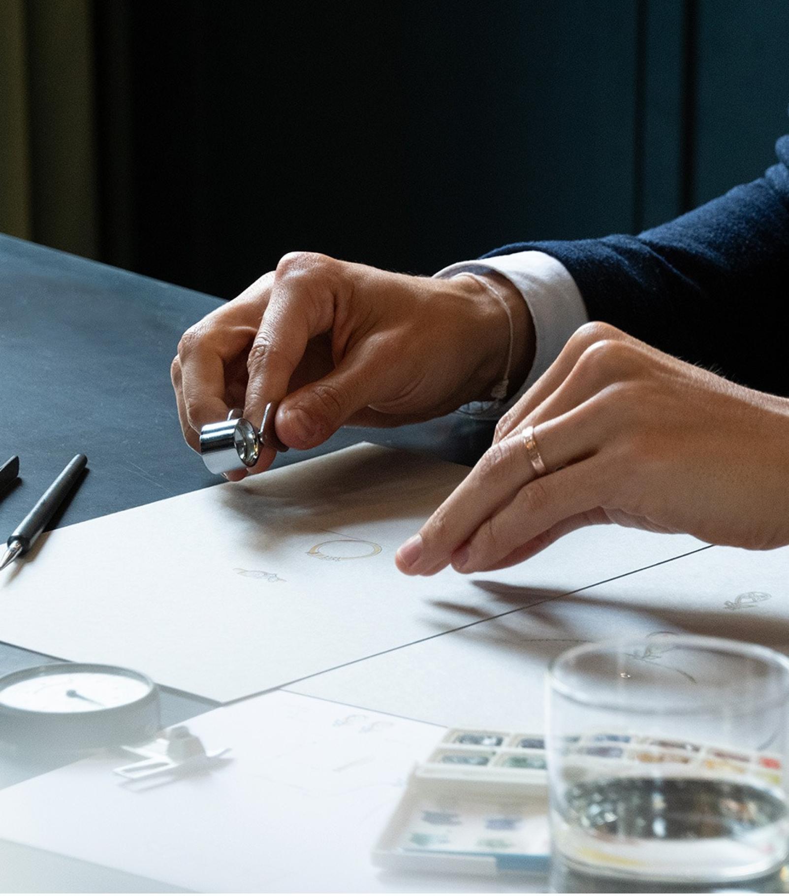 A designer working with gemstones and materials to create a jewellery piece